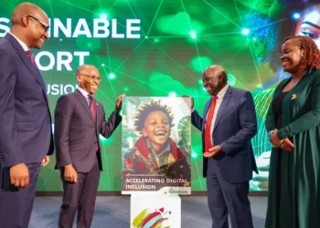Safaricom CEO Peter Ndegwa standing next to a dummy of the 2024 Safaricom Sustainability Report