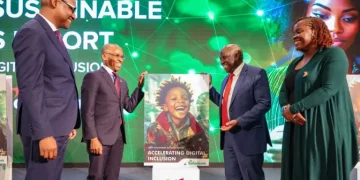 Safaricom CEO Peter Ndegwa standing next to a dummy of the 2024 Safaricom Sustainability Report