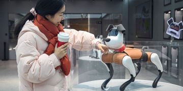 A woman checking an AI pet dog at a store.