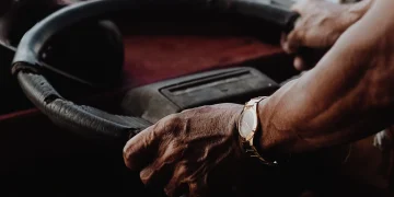 Older driver holding steering wheel
