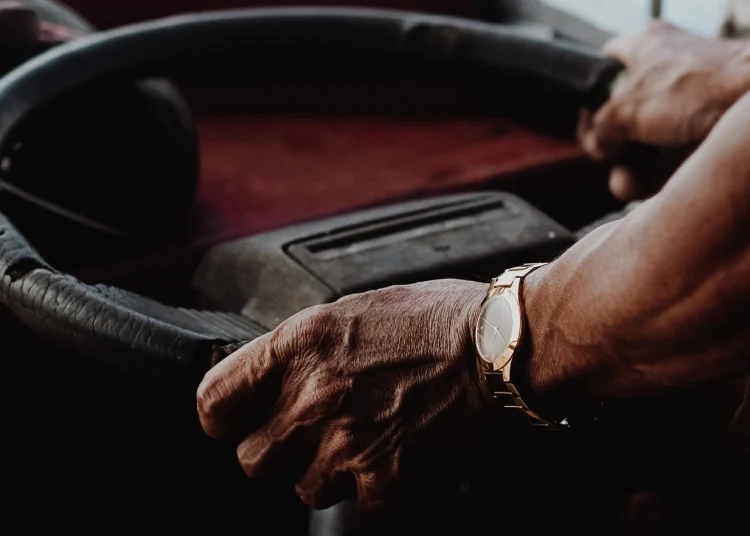 Older driver holding steering wheel